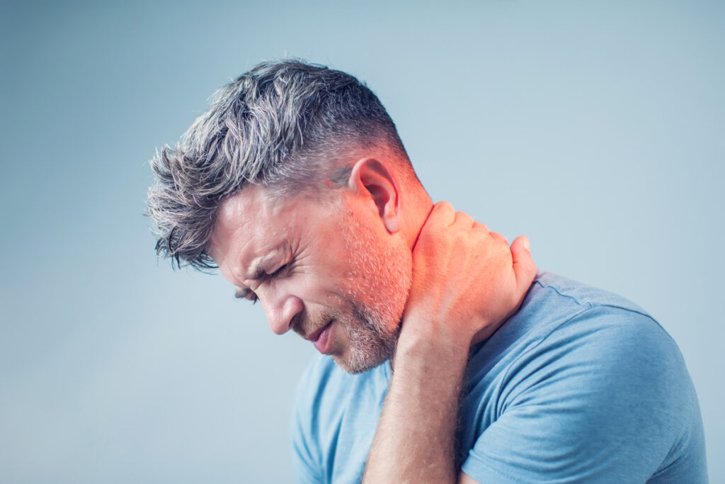 A man in a blue shirt grabbing his neck in pain due to complex regional pain syndrome in Bethesda.