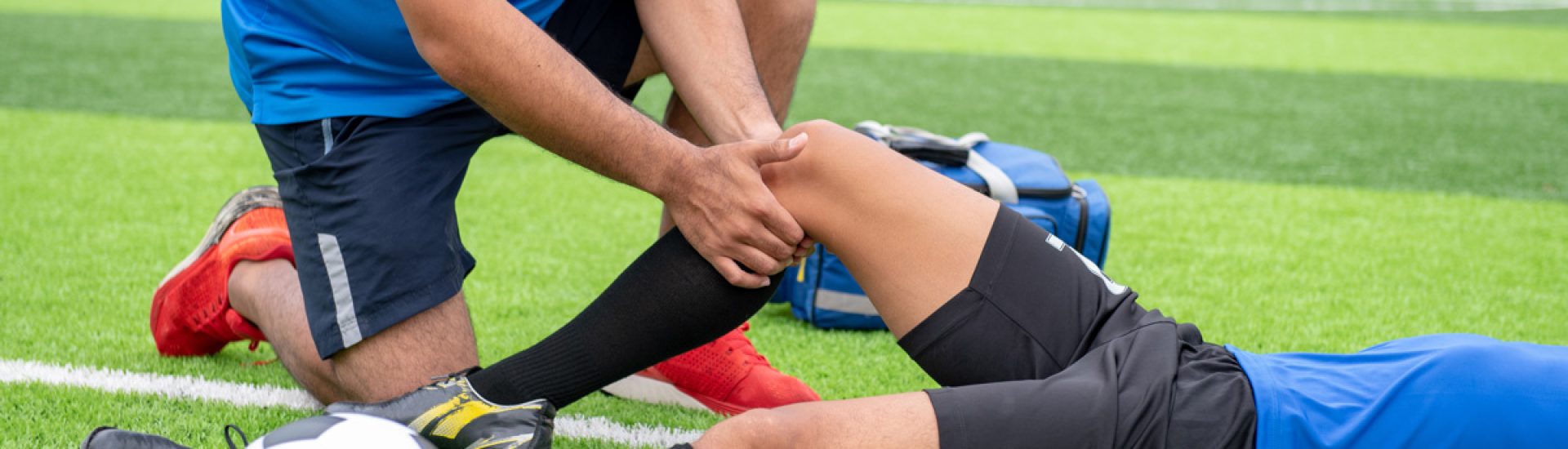 A person laying down injured on a soccer field in Bethesda. In need of physical therapy