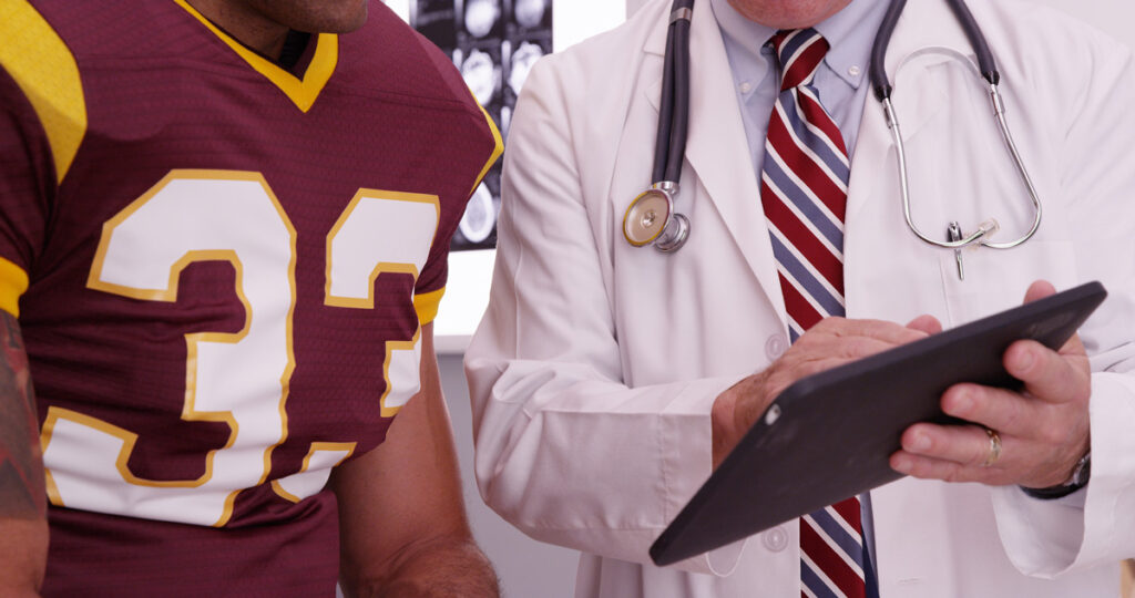 A doctor speaking with a person in a football jersey in Bethesda.